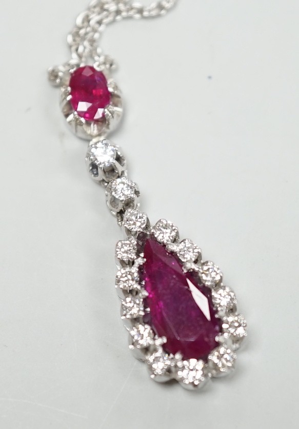 A modern 750 white metal, two stone ruby and fifteen stone diamond set pear shaped drop pendant necklace, pendant, 34mm, chain, 40cm, gross weight, 7.1 grams.